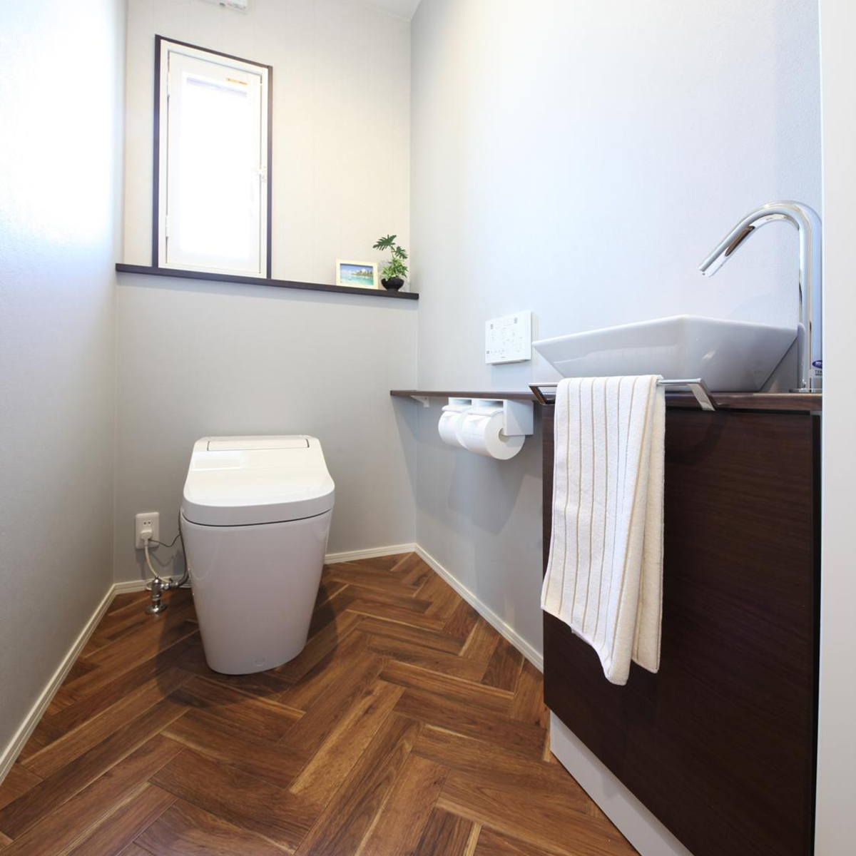ヘリンボーン柄の床が印象的なトイレ