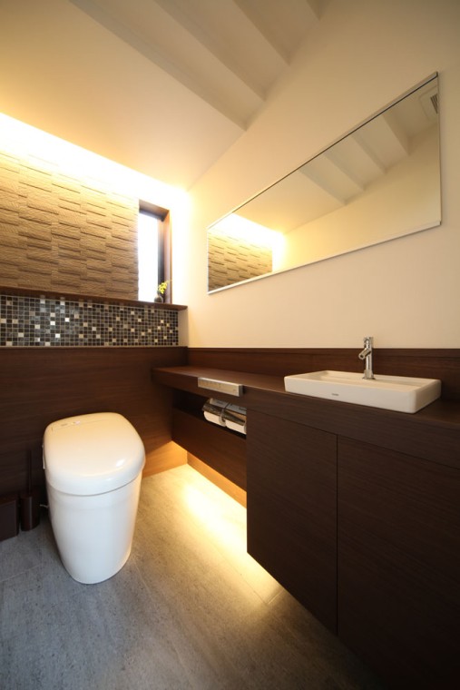 グレーを基調にトイレの背面の腰壁やカウンター・手洗いをブラウン系にして温もりある空間に。